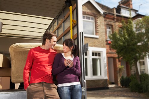 Professional movers carrying furniture through a local property entrance